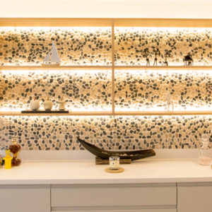 We created a statement shelving area with pebble tiles and backlights