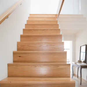 Staircase design by Rudi Tyrell with glass balustrade, with sleek storage underneath