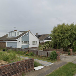 This view from the street shows the old dormer window and small porthole window on the front elevation