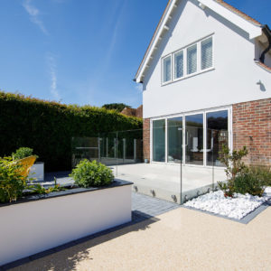 The patio from the house is the same height as the inside flooring. This gives a seamless transition to the outside. The glass balustrade also adds to the inside-outside look and feel.