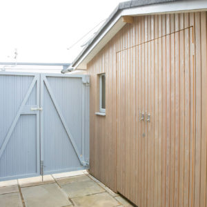 The vertical larch cladding on the shed matches in with the cladding on the garden room