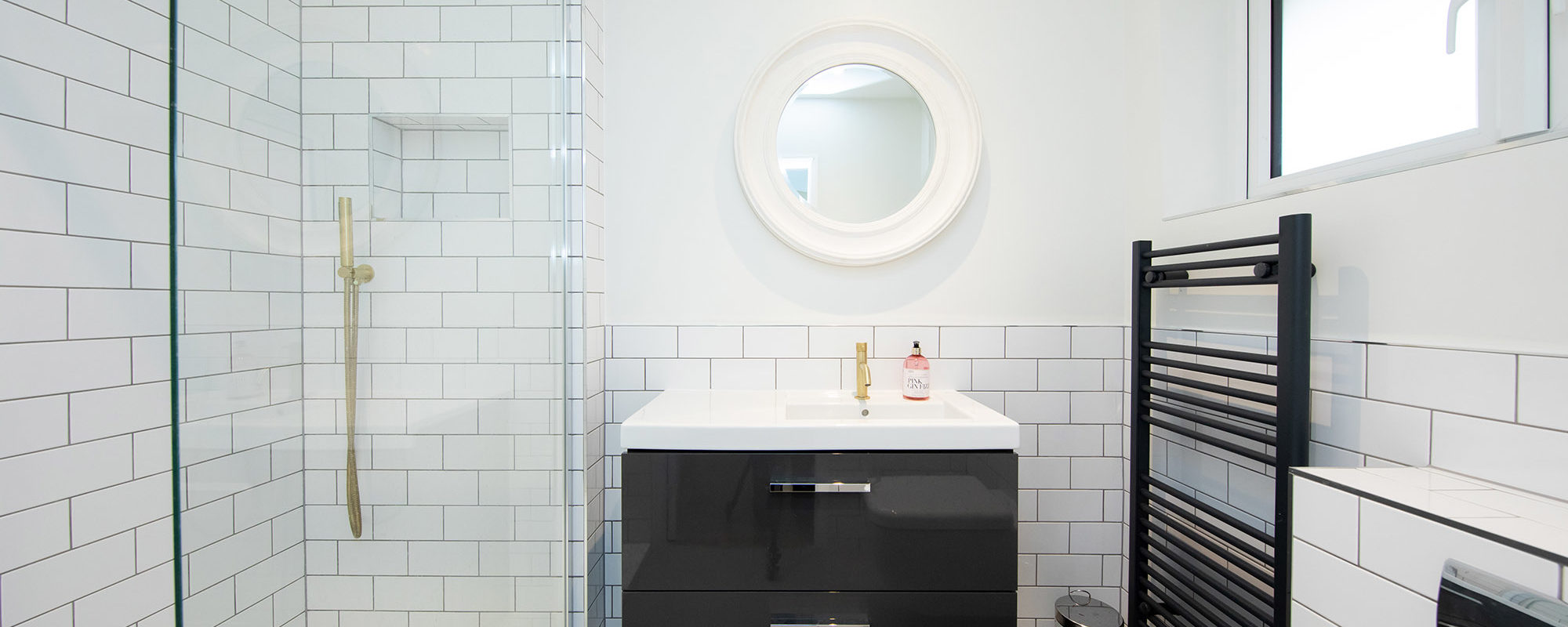 Dark grey towel rail and vanity units are set off my the dark grey tile grout