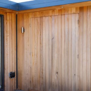 New door built to blend into cladding on garden room