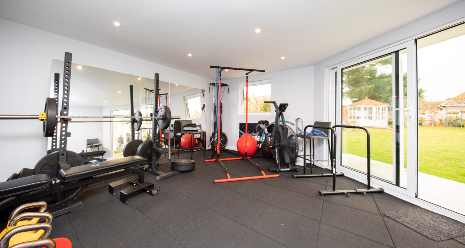 Look how much gym equipment fits inside this space. the angled entrance creates a nice outlook onto the garden