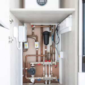 Neat pipework hidden from view in this easily accessible cupboard in the kitchen