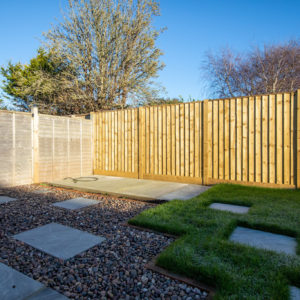 Sunken patio slabs amongst the scottish cobbles make up the path to the space ready for a garden shed