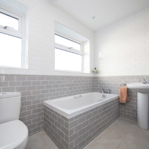 The beach grey and white colour scheme continues into the bathroom