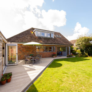 decking wraps around the garden linking the main house with the garden room