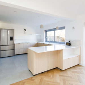 A tiled floor in the kitchen joining the herringbone solid oak floor in the dining room and hallway