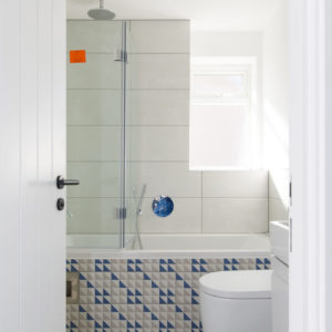 Running the tiles up the bath creates a larger looking room