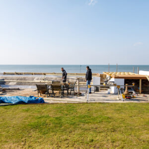 The concrete wall is being clad with a long bench seat incorporated into it