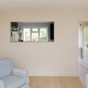 The open window through to the kitchen lets in light but also connects the two rooms