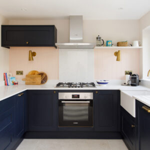 The dark navy kitchen is super modern, and is set off beautifully with a pale pink wall colour