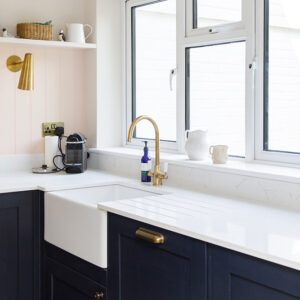 A butler style sink sits under the stone worktop