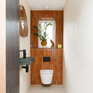 In the hallway WC we have used the same style tiles as the ensuite but in a darker colour