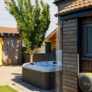 The outdoor shower was moved from the driveway into the back garden, and the splashback matches perfectly with the garden styling