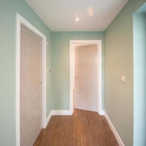 Inside, a small hallway leads to a bathroom and utility room