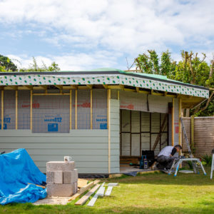 The garden room fits snugly into the corner of this large garden with a diagonal large opening for the sliding doors